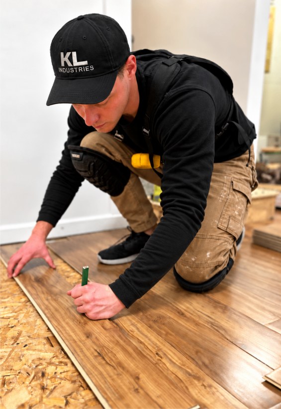 Kaleb of KL Industries installing hardwood plank flooring